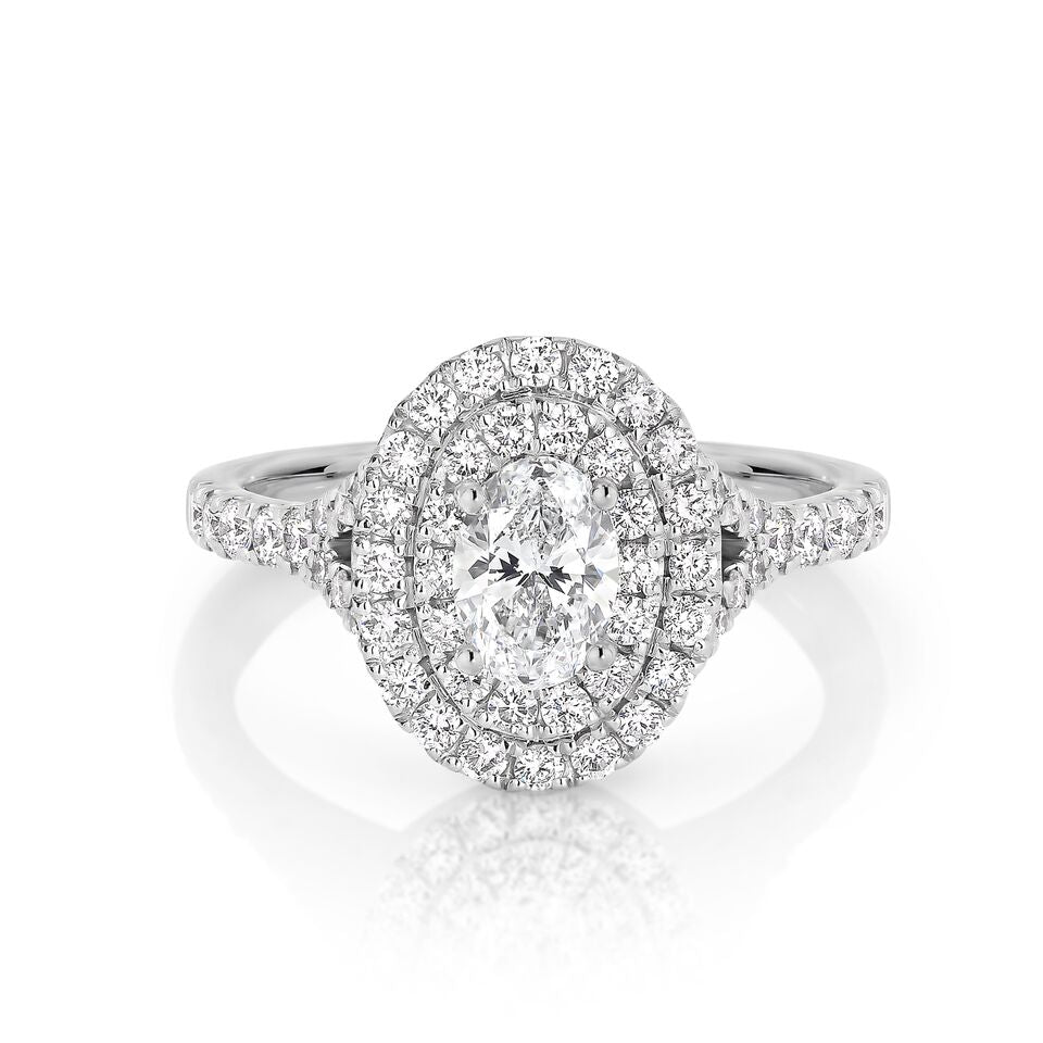OVAL HALO RING. 1.10 CT TOTAL WEIGHT. 18K WHITE GOLD