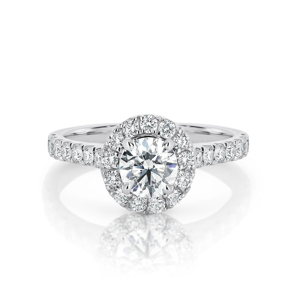 GIA certified round 0.70 ct F/SI2 set in 18K W/G halo ring. TCW 1.30+ cts